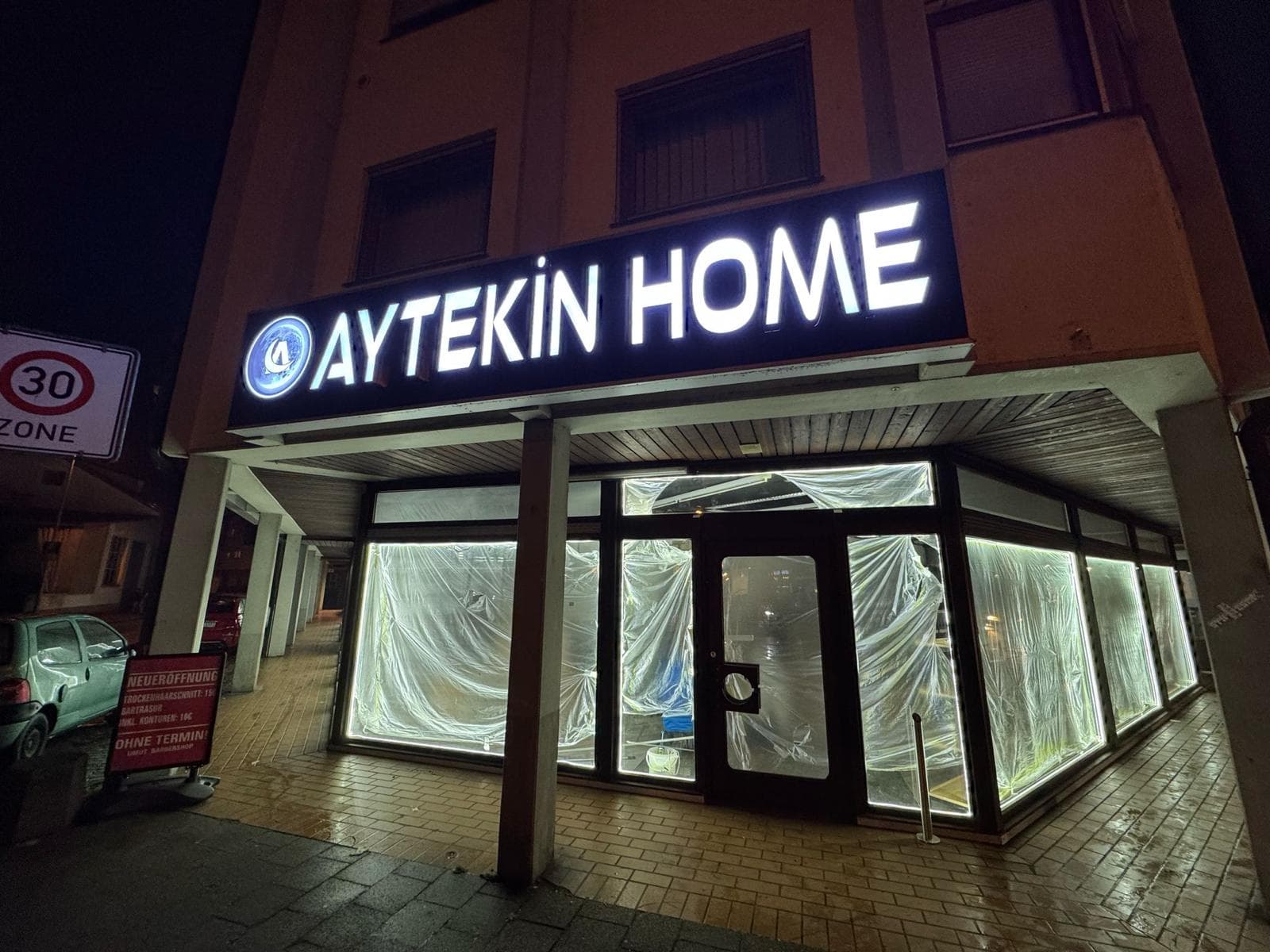 Enseigne bleue Aytekin Home et vitrines habillées, vue de face