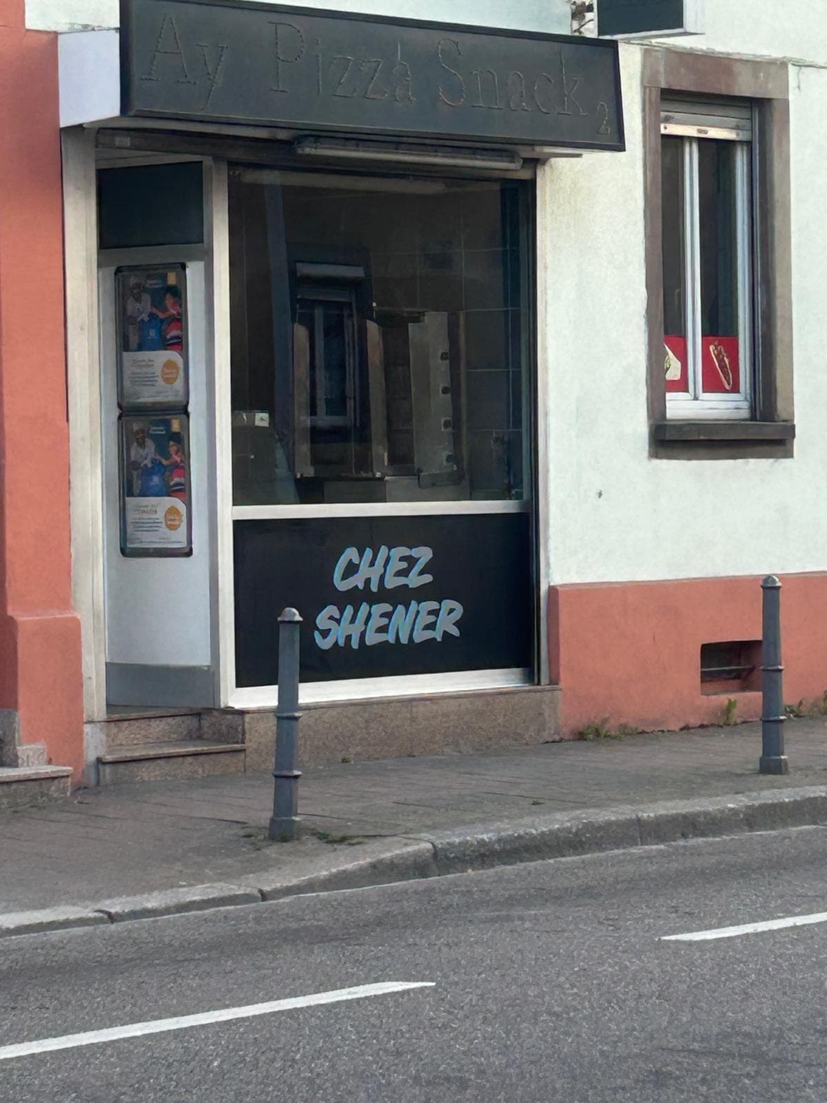 Devanture Chez Shener avec enseigne peinte en blanc sur fond sombre