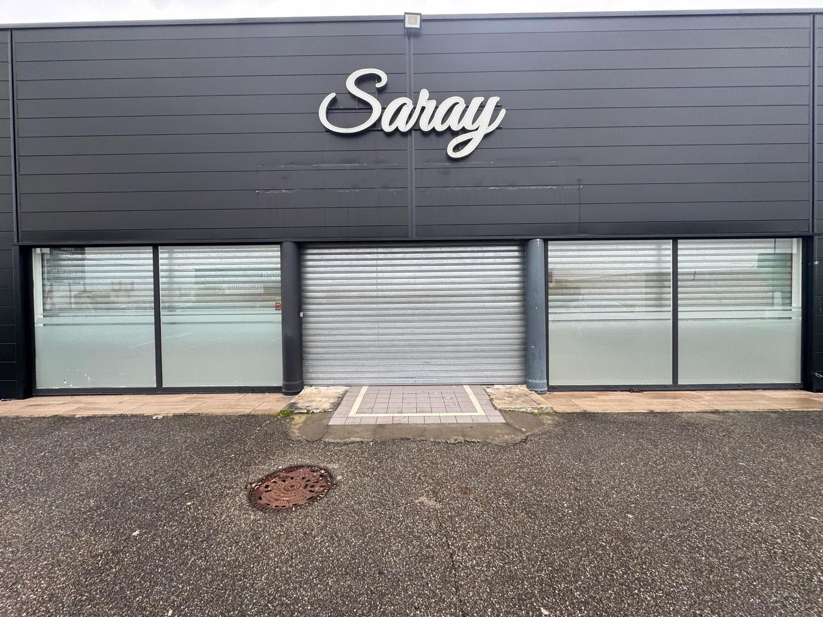 Enseigne Saray en lettres blanches découpées sur bardage sombre