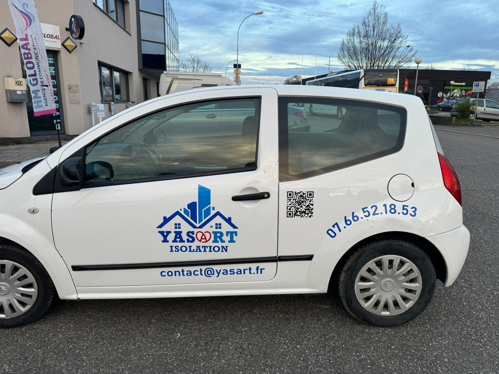 Citroën C2 blanche marquée sur le flanc aux couleurs YASART Isolation
