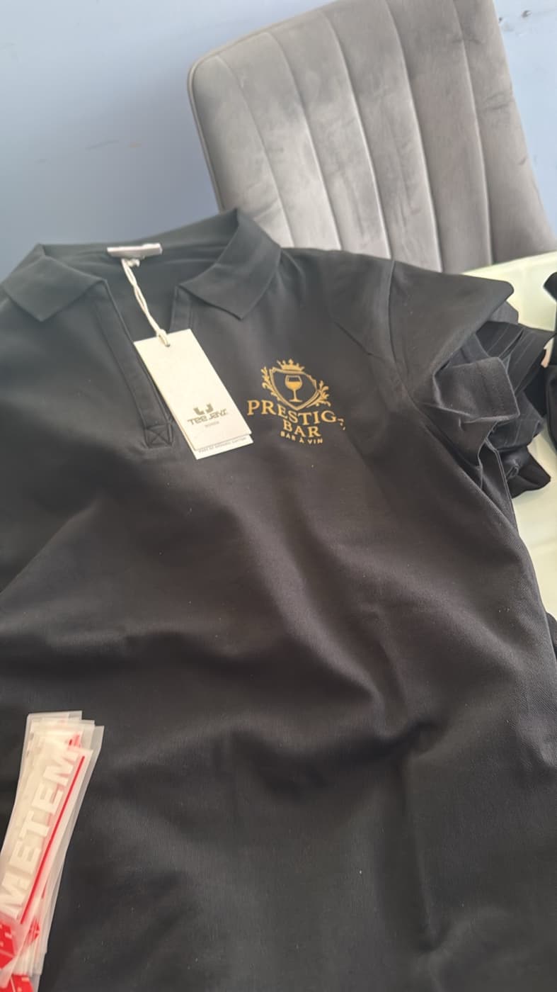 Polo noir Prestige Bar à Vin avec logo doré brodé côté cœur